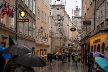 Salzburg, Avusturya - 22 Aralık 2024: Yağmurlu bir günde Noel 'de Salzburg' da Getreidegasse caddesi süslendi