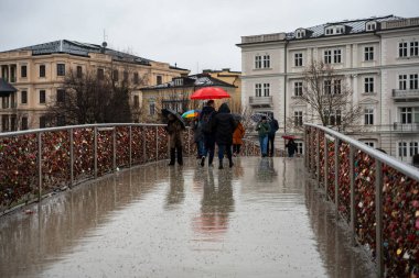 Salzburg, Avusturya - 22 Aralık 2024: Yağmurlu Salzburg 'da sayısız asma kilitli yaya köprüsü