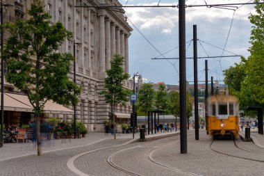 Budapeşte, Macaristan - 24 Mayıs 2025: Retro tramvay hareket bulanıklığıyla Parlamento yakınlarında durduruldu