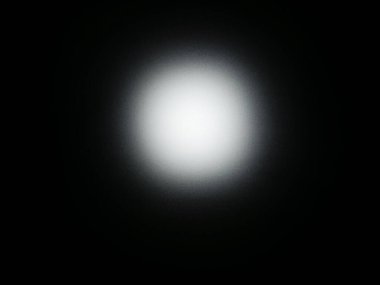 Parlak beyaz bir spot ışığı tamamen siyah bir arkaplanda dairesel bir aydınlanma yaratır. Işık merkezden yavaş yavaş kaybolur ve yumuşak, parlayan bir halo etkisi yaratır. Bu yüksek kontrastlı soyut resim arka planda kullanmak için mükemmeldir