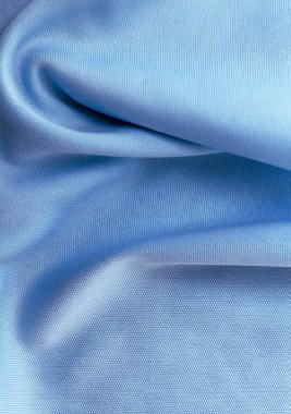 Açık mavi kumaşın yakın çekim makro fotoğrafı ince dokuma dokusu ve yumuşak kıvrımları sergiliyor. Görüntü ayrıntılı iplikleri ve ince gölgeleri vurgular, onu tekstil arka planları, kumaş tasarım ilhamı veya malzeme çalışmaları için ideal hale getirir.