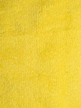 Yakın çekim makro fotoğraf parlak sarı mikrofiber kumaşın yumuşak ve detaylı dokusunu gösteriyor. Geçmişler, tekstil tasarım şablonları ya da temizlik ürünü konseptleri için idealdir. Yüzeyde kalın, pelüş ve emici bir desen var.