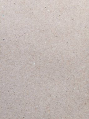A high-resolution photo showing a close up of a beige recycled paper surface. The texture displays visible natural fibers and specks, offering an organic and eco-friendly appearance suitable for use in backgrounds, packaging, or design projects.