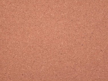 Close-up photo of a brown cork board texture with a natural, rough, and granular surface. This seamless background is ideal for use in design projects, presentations, or as a backdrop for note displays and creative workspaces.