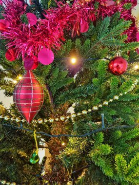 Kırmızı topları, yeşil ökseotu yaprakları ve lambası olan birçok çeşit Noel süsü.