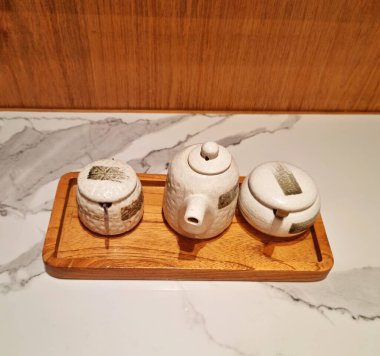 Jakarta, Endonezya - 02 Aralık 2024: Japon restoranında ketçap, acı biber ve wasabi için beyaz kil kavanozu