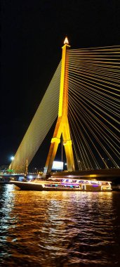 Bangkok, Thailand - Sept 14, 2024: Picture of illuminated Phra Pinklao Bridge taken from Chao Phraya river at night clipart