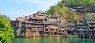 Zhangjiajie, Çin - 07 Nisan 2025: Fenghuang Antik Kentinde Diaojiaolou olarak bilinen geleneksel ahşap ev mimarisi iyi korunmuş nehir suyu üzerinde
