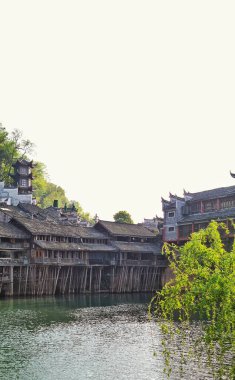 Zhangjiajie, Çin - 07 Nisan 2025: Fenghuang Antik Kentinde Diaojiaolou olarak bilinen geleneksel ahşap ev mimarisi iyi korunmuş nehir suyu üzerinde