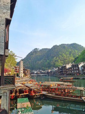 Zhangjiajie, Çin - 2007, 2025: Fenghuang Antik Kenti 'ndeki çok katlı pagoda kulesinin önde gelen geleneksel Çin mimarisi geleneksel stilt evler, renkli tekneler ve deniz manzarası