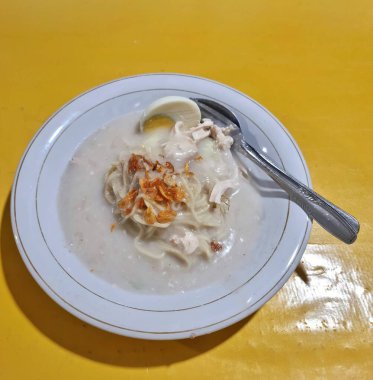 Cirebon, Endonezya - 11 Mayıs 2025: Bir tabak geleneksel Cirebonese yemeği kremsi beyaz et suyunda erişte, tavuk parçaları, haşlanmış yumurta ve serpilmiş kızarmış arpacık soğanı