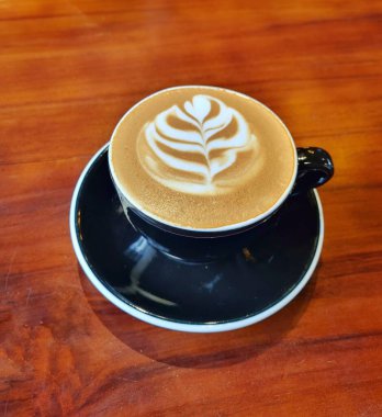 Bandung, Endonezya - 16 Mayıs 2025: Katmanlı ve tüylü latte sanat tasarımı kremalı köpüklü kahve