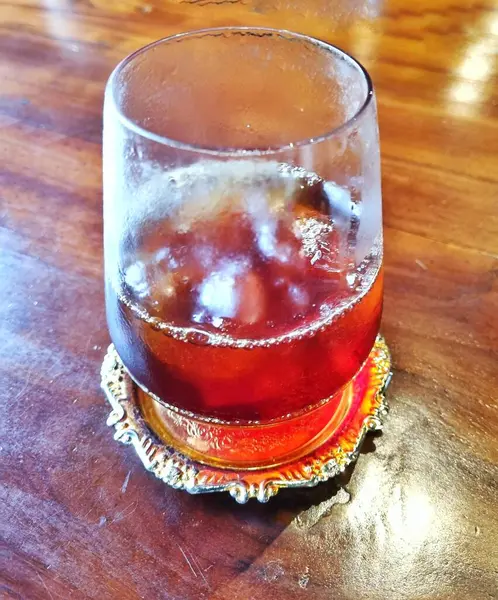 Bandung, Endonezya - 16 Mayıs 2025: Buzlu buzlu kahve ve küçük süslü altın renkli bardak