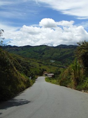Yol, dağlara doğru bir manzara, mavi gökyüzü.
