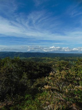 Güneşli bir günde, arka planda büyük, güzel dağlar olan manzara bulutlar ve mavi gökyüzü..