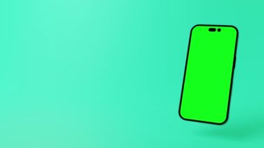 Uygulama modelleri, reklamlar, açıklayıcı videolar gibi içerik yerleştirme için yeşil ekranlı modern akıllı telefon. Nane yeşili arka plan. Yüksek kalite 4k görüntü