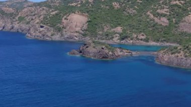 Sardunya 'nın engebeli bir kıyısında kristal mavi suyla hava aracı görüntüsü. Yüksek kalite 4k görüntü