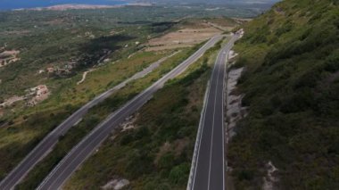 Arka planda kıyı şeridi olan kıvrımlı bir dağ yolunda mavi italyan eski zamanlayıcının drone çekimi. Yüksek kalite 4k görüntü
