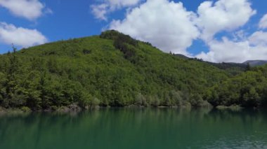 Güzel dağ gölü ve arka planda dağ. Huzurlu dağ gölünün insansız hava aracı çekimi. Yüksek kalite 4k görüntü.