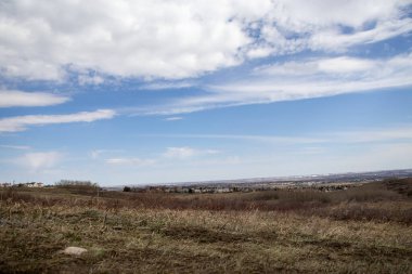 Dağınık yerleşim düzenine sahip kırsal ya da banliyö manzarasını gösteren sayısız evin olduğu bir tarlayı tasvir eden bir resim..