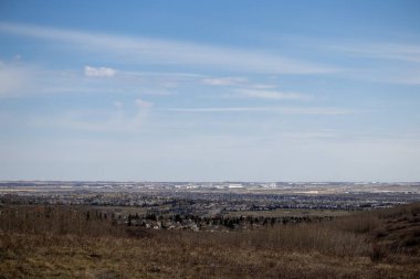 Dağınık yerleşim düzenine sahip kırsal ya da banliyö manzarasını gösteren sayısız evin olduğu bir tarlayı tasvir eden bir resim..