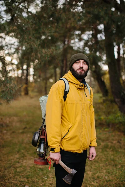 Horizontal portrait of a traveling young man surviving in the mountains with a backpack. Traveler man with beard trekking and mountaineering. Travel, people, healthy lifestyle concept