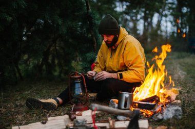 Gezgin bir gaz lambası kullanır. Gece için ormanda bir barınak hazırlıyorum..
