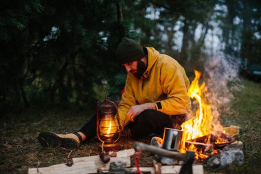 Gezgin bir gaz lambası kullanır. Gece için ormanda bir barınak hazırlıyorum..