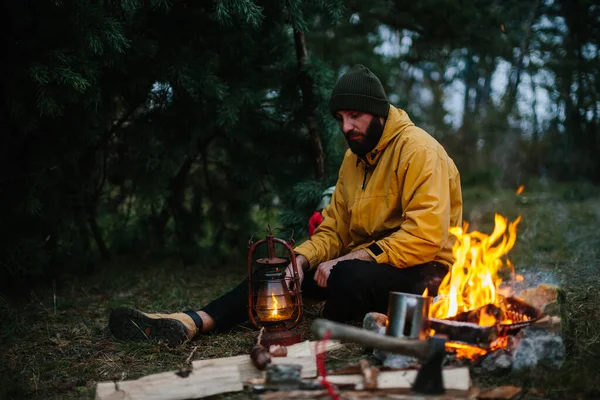 The traveler uses a kerosene lamp. Setting up a shelter in the forest for the night.