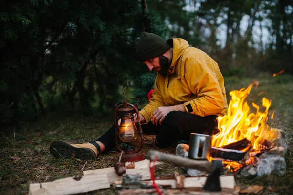 The traveler uses a kerosene lamp. Setting up a shelter in the forest for the night.