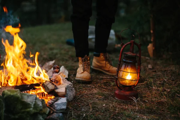 旅行者は灯油ランプを使用しています 夜の森の中に避難所を設置する — ストック写真