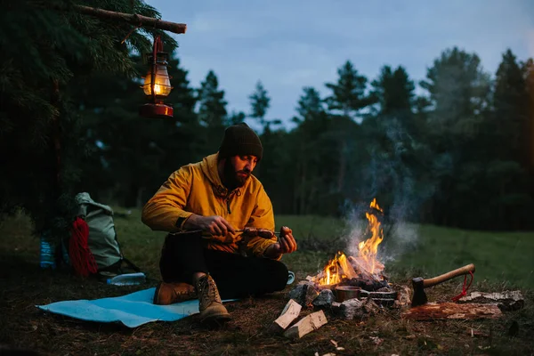 Young Bearded Man Preparing Grilled Sausage Wooden Stick Campfire Night — Stock Photo, Image