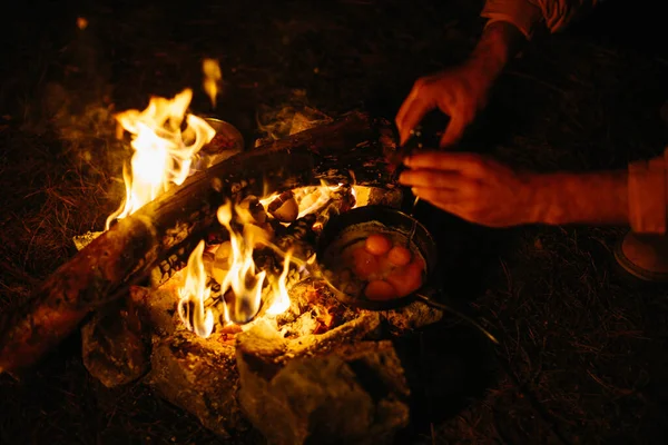 旅行者在篝火上煎鸡蛋 野外旅行和生存的概念 — 图库照片
