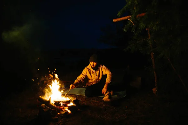 여행자는 모닥불 옆에서 석유램프와 둘러싸인 사용하여 나뭇가지에 피신처 — 스톡 사진
