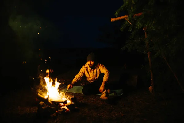 旅行者在夜间篝火边休息 用树枝装饰掩蔽所 用煤油灯和被石头围住的火睡觉 — 图库照片