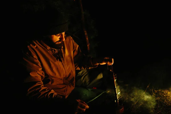 旅行者在夜间篝火边休息 用树枝装饰掩蔽所 用煤油灯和被石头围住的火睡觉 — 图库照片