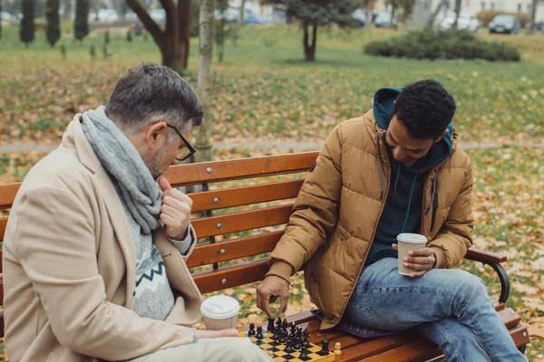 Φίλοι Παίζουν Σκάκι Ένα Παγκάκι Ένα Πάρκο Φθινόπωρο Πολυπολιτισμική Φιλία — Φωτογραφία Αρχείου