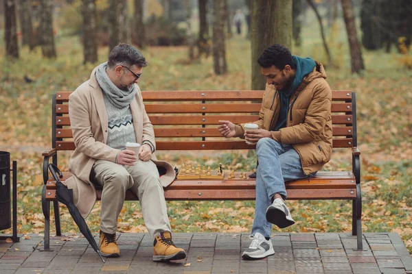 Çok Irklı Erkekler Öğretmen Öğrenci Sonbahar Parkında Bankta Satranç Oynuyorlar — Stok fotoğraf