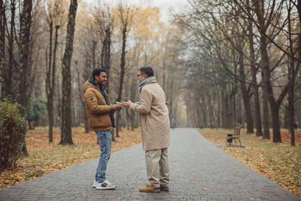 Amigos Anciano Joven Caminando Hablando Tomando Café Juntos Parque Otoño — Foto de Stock