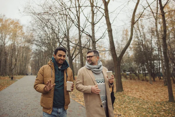 Amigos Anciano Joven Caminando Hablando Tomando Café Juntos Parque Otoño — Foto de Stock
