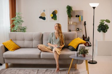 Stylus kalemle grafik tabletine çizen mutlu genç tasarımcı. Yeni bir tasarım üzerinde çalışırken gülümseyen kadın grafik tasarımcısı. Kendi ofisinde çalışan yaratıcı genç bir serbest yazar..