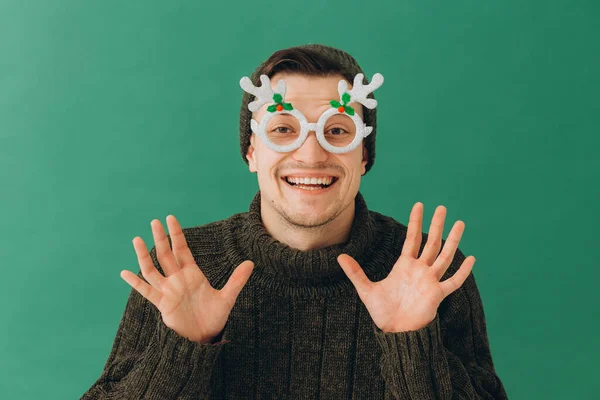 Ein Junger Mann Warmem Pullover Mütze Und Karnevalsbrille Auf Grünem — Stockfoto