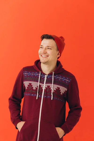若いです男でクリスマスセーターと帽子上の色の背景 — ストック写真