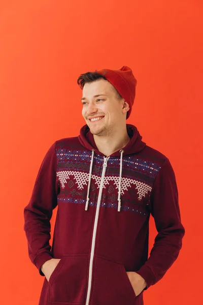 若いです男でクリスマスセーターと帽子上の色の背景 — ストック写真