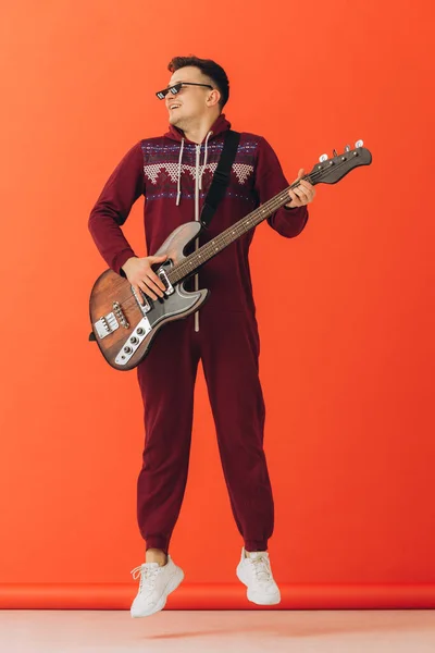 クリスマス キグルミの若い男がカラーを背景にエレキギターを弾く — ストック写真