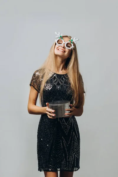 メリークリスマス クリスマスプレゼントを保持するお祭りのドレスの幸せなブロンドの女性 肖像画 ストックフォト — ストック写真