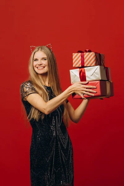 圣诞快乐 一个穿着节日服装的快乐的金发女人举行圣诞礼物 肖像画 库存照片 — 图库照片