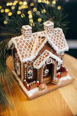 Masada jöleli küçük zencefilli kek evi. Işıkları ve Noel ağacı olan oturma odası. Tatil havası.