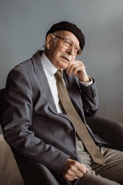 Düşünceli son sınıf 80 'lerin dedesi evde koltukta dinleniyor. Kaybolduğunu hatırlamakta güçlük çekiyor..