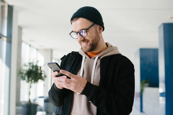 Young Man Casual Outfit Chats Mobile Phone While Standing Hall — Stock Photo, Image